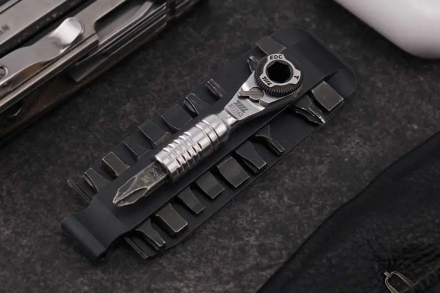 EDC Mini-Ratschenschlüssel auf Bit-Halteplatte mit Bits im Hintergrund