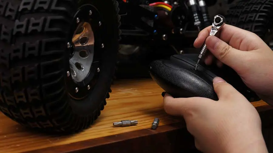 EDC-Mini-Ratschenschlüssel neben kompaktem Adapter und Bits auf schwarzem Untergrund
